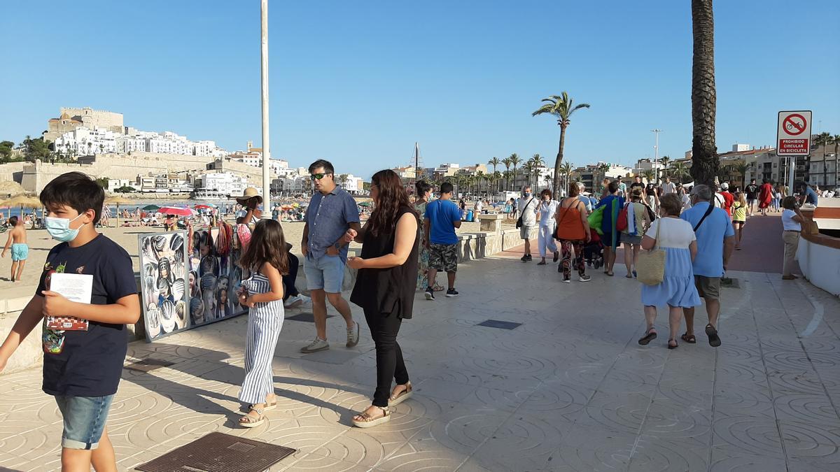 Vecinos de la localidad y turistas paseando por el paseo marítimo de Peñíscola.