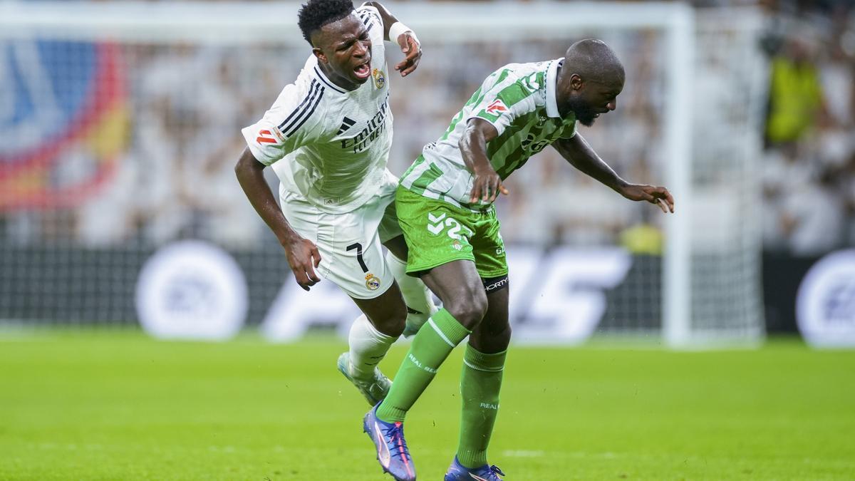 El delantero brasileño del Real Madrid Vinicius lucha con Youssouf Sabaly, del Betis, durante el partido de la cuarta jornada de LaLiga entre el Real Madrid y el Real Betis, este domingo en el estadio Santiago Bernabéu.