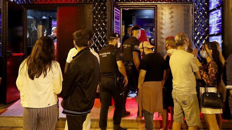 Los agentes de la Policía Local controlando el cumplimiento de las normas del Covid-19 en un local de ocio nocturno en Vigo. / J. Lores