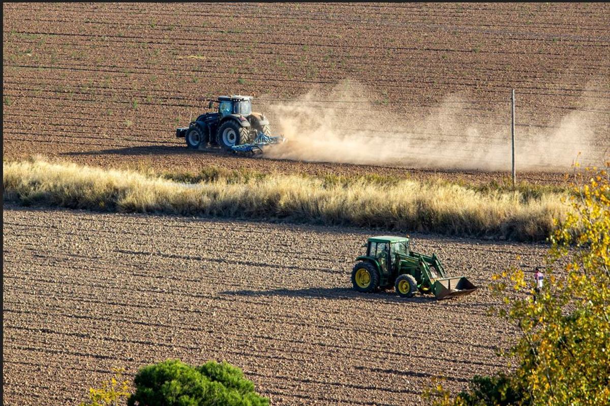 Dos pagesos treballant amb els tractors.