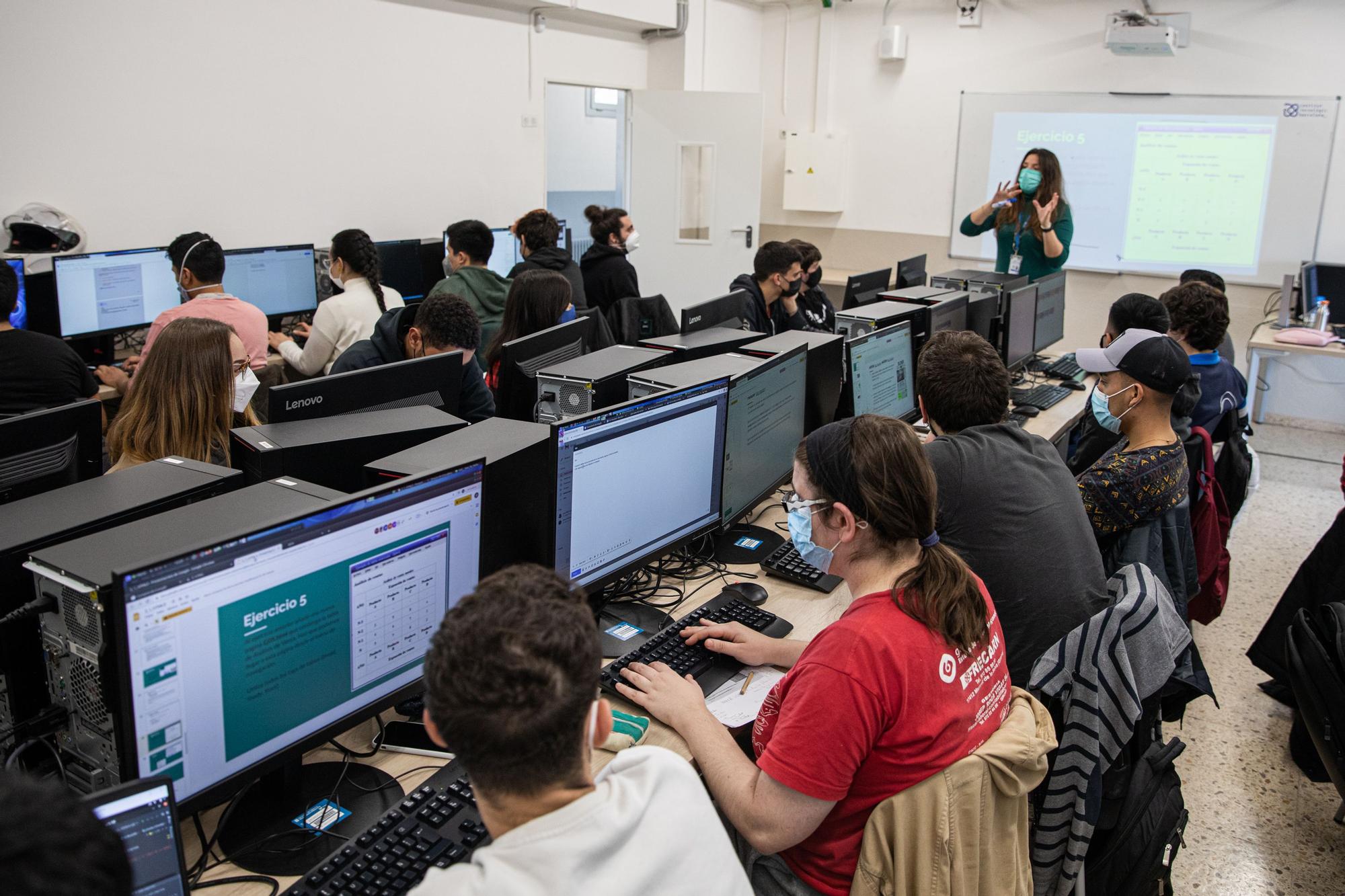 Un grupo de jóvenes, la mayoría varones, en una clase de aplicaciones web.