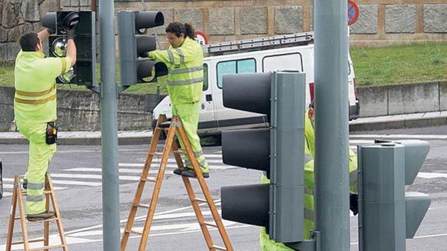 Operarios durante la sustitucion de las bombillas de los semáforos por lámparas led.  // Iñaki Osorio