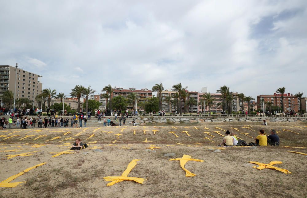 Estenen tovalloles grogues en forma de creu a la platja de Mataró