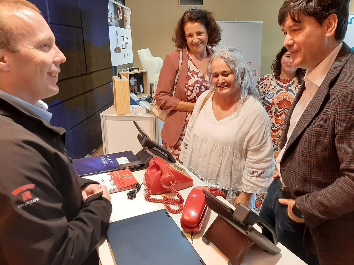 Por la izquierda, Álvaro Rodriguez, de Tapia Sistemas, muestra la evolución de los teléfonos fijos a Sonia Verde, Eva María Pérez y Borja Sánchez