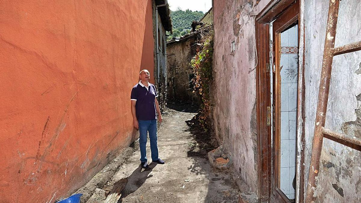 Manuel Prado, presiente de la asociación de vecinos, observa el estado de una de las caleyas de La Villa. 