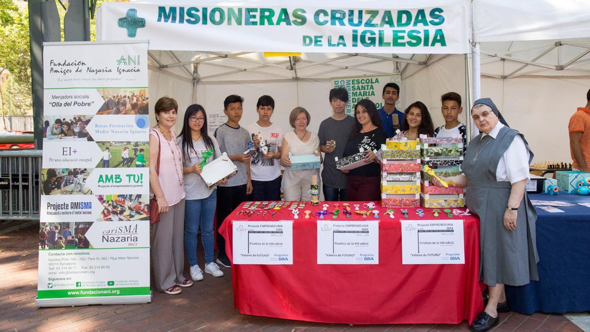 Los alumnos participantes en la asignatura de emprendeduría de la Escola Santa Maria dels Apòstols posan en su parada solidaria.