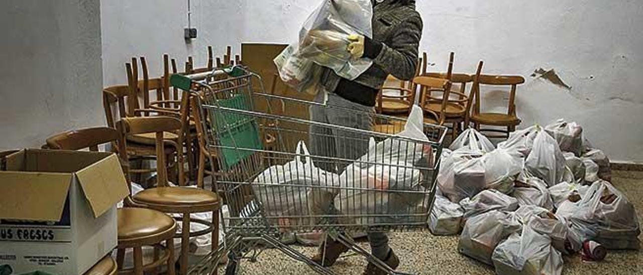 Una voluntaria de Mallorca sense Fam prepara bolsas de alimentos durante el confinamiento.
