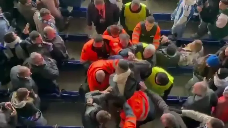 La seguridad del RCD Stadium se lleva a un aficionado tras una pelea en la grada con otros aficionados