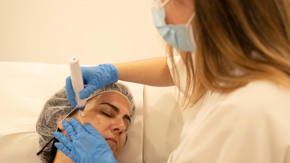 Cristina Muñoz, enfermera de Eiviestetic, aplica un tratamiento en la piel de una paciente.