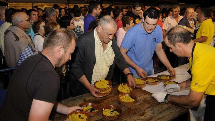 La distribución de las raciones procedentes de la gigantesca paella fue anoche el momento más aguardado. // Bernabé/Javier Lalín