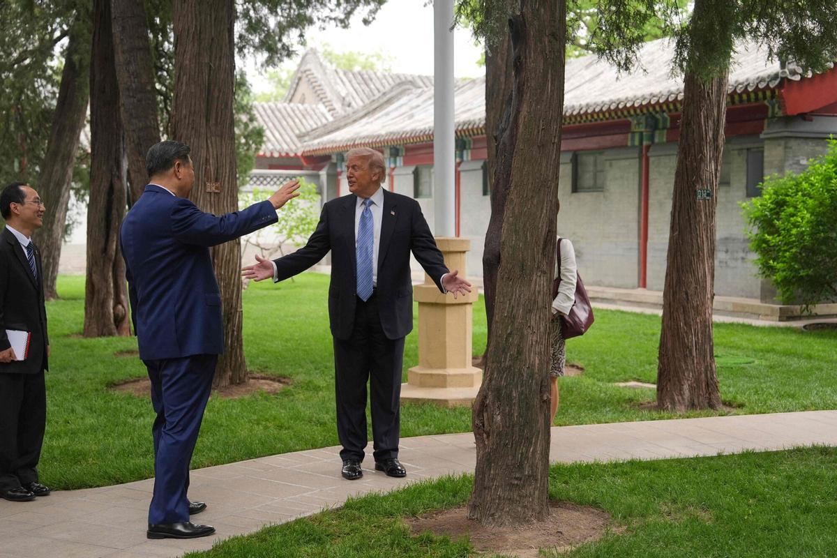 US President Donald Trump (R) and China’s President Xi Jinping (C) visit the Zhongnanhai leadership compound in Beijing on May 15, 2026. (Photo by Mark Schiefelbein / POOL / AFP)