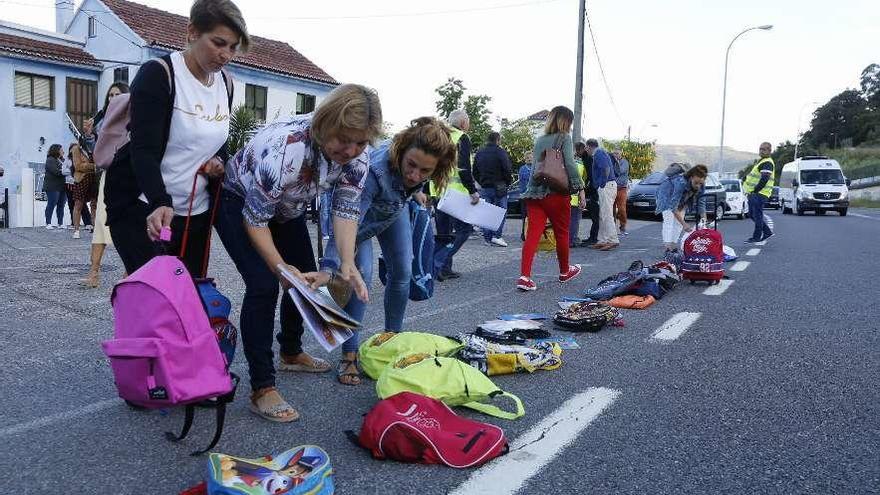 La &quot;concentración de mochilas&quot;, ayer, en la N-552 junto al colegio del barrio de Angorén. // Ricardo Grobas