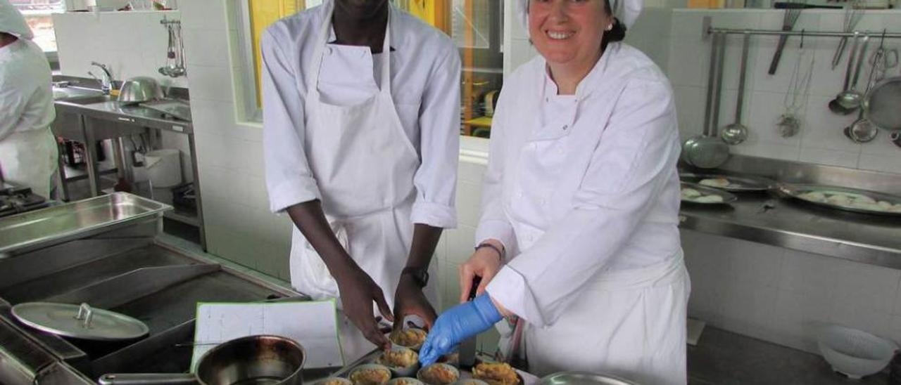 Lamine Ndiaye y Montse Sánchez, ayer, en la cocina del IES de Llanes.