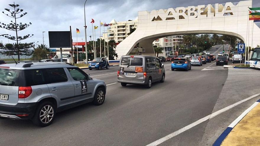 Parte de los vehículos de la caravana reivindicativa pasa por el Arco de Marbella. | L. O.