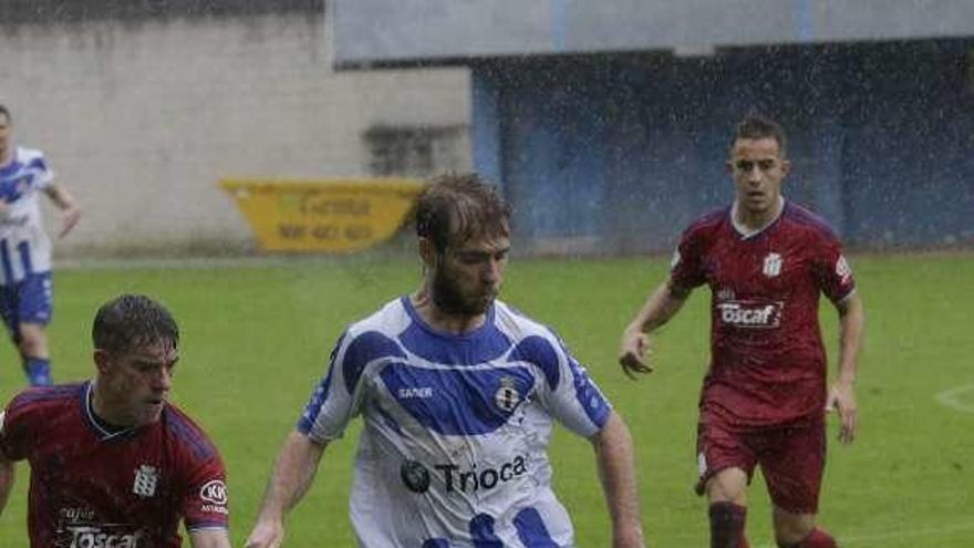 Imanol, ante dos adversarios en un lance del Real Avilés-Praviano de la primera vuelta.