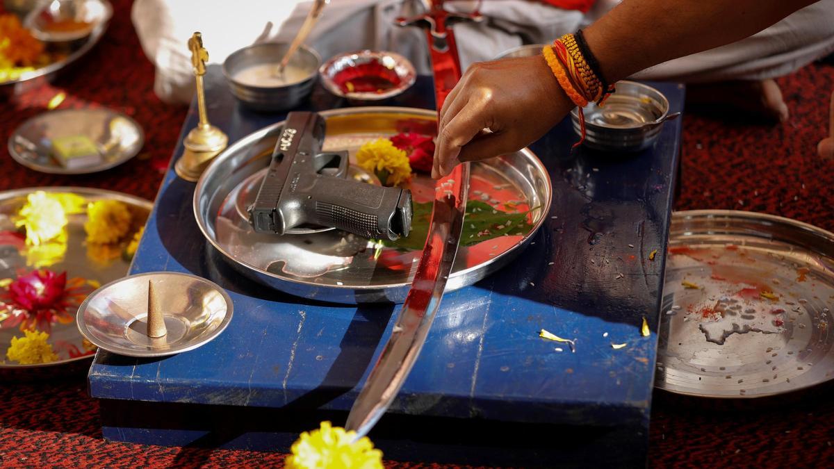 A police officer offers a prayer to his weapon as part of a ritual at their headquarters on the occasion of Dussehra, or Vijaya Dashami, festival in Ahmedabad