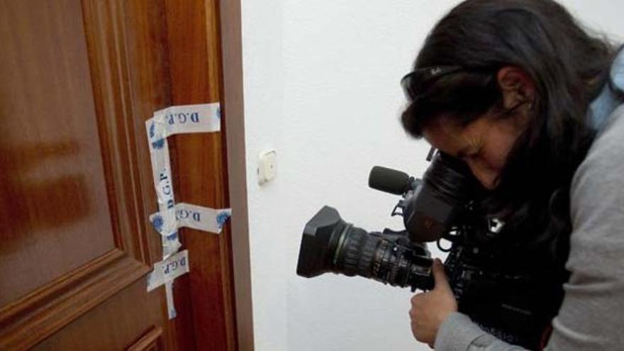 Un cámara de televisión toma imágenes de la puerta del domicilio donde ayer fue encontrada una mujer de 55 años cuidadora de un anciano, muerta con signos de violencia.