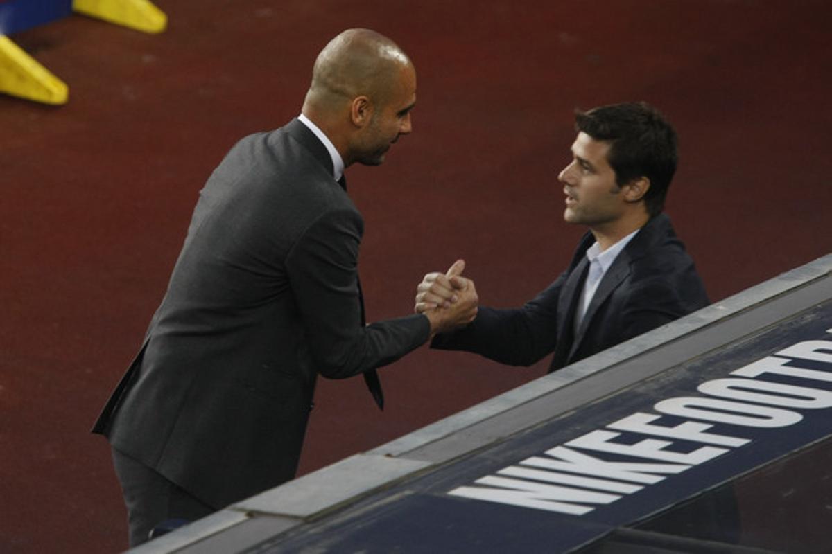 Los entrenadores del Barcelona y del Espanyol, Pep Guardiola y el argentino Mauricio Pochettino, respectivamente, se saludan momentos antes de comenzar el partido.
