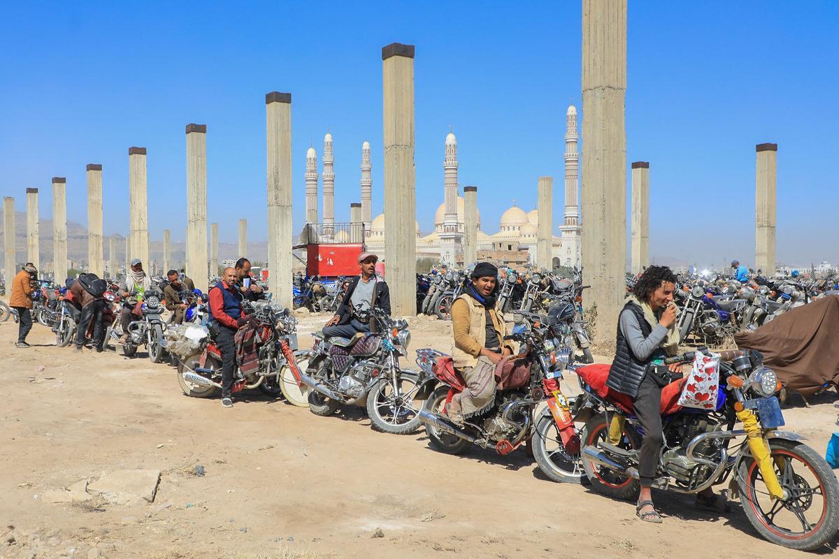 Los yemeníes se reúnen en medio de motocicletas mientras esperan que se les expidan licencias para conducir como parte de una campaña de seguridad de las autoridades huzíes, en Yemen