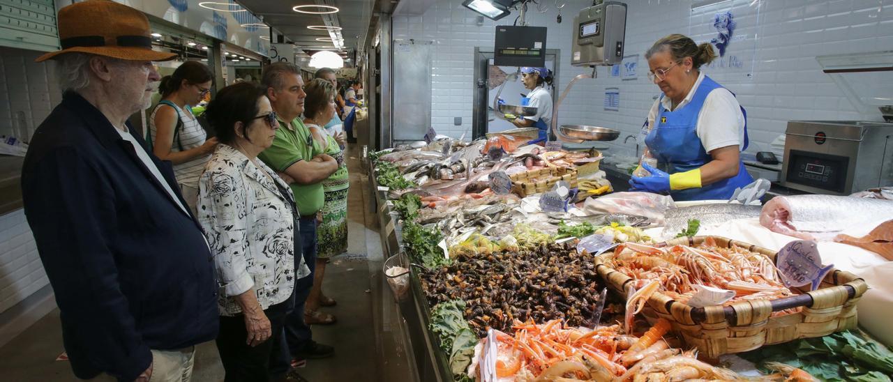 Varias personas comprando alimentos en un mercado