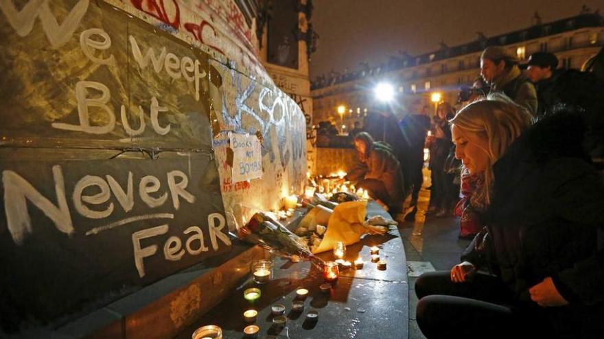 Personas concentradas con velas y ramos de flores en el centro de París, en las inmediaciones de los escenarios los atentados.