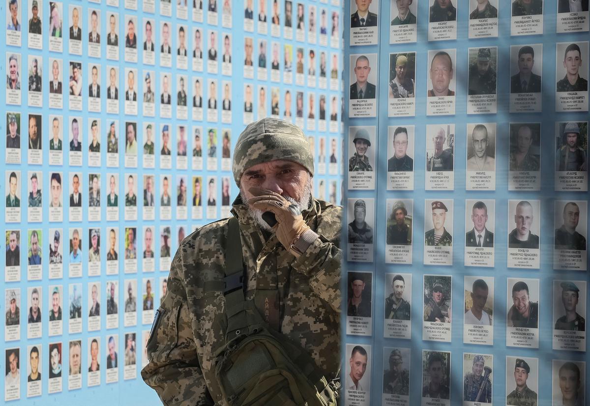 La gente visita el Muro del Recuerdo para conmemorar el Día de los Voluntarios en honor a los combatientes muertos que se unieron a las fuerzas armadas ucranianas.