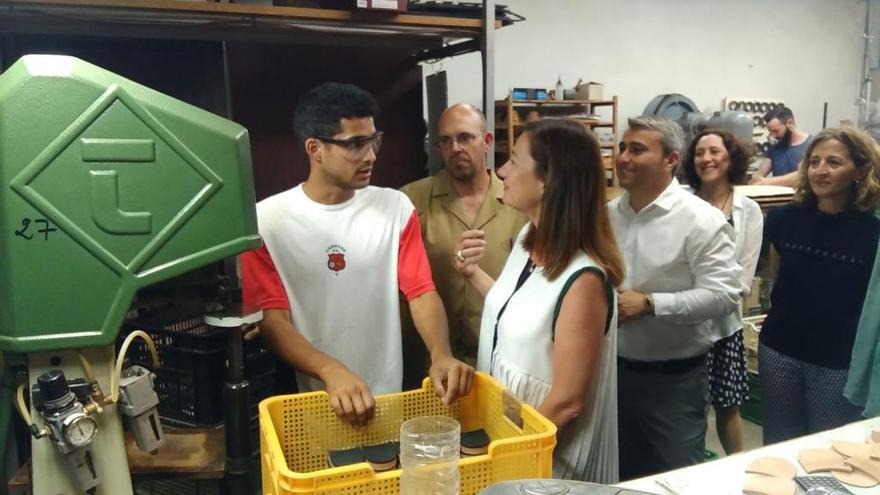 Francina Armengol conversado con un alumno en prácticas de la fábrica Carmina Shoemaker