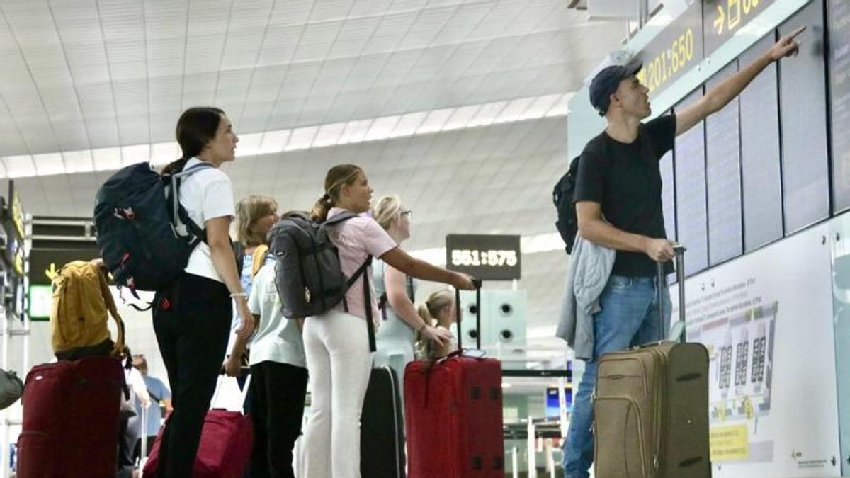 Viatgers consulten l'estat dels vols a l'aeroport de Barcelona