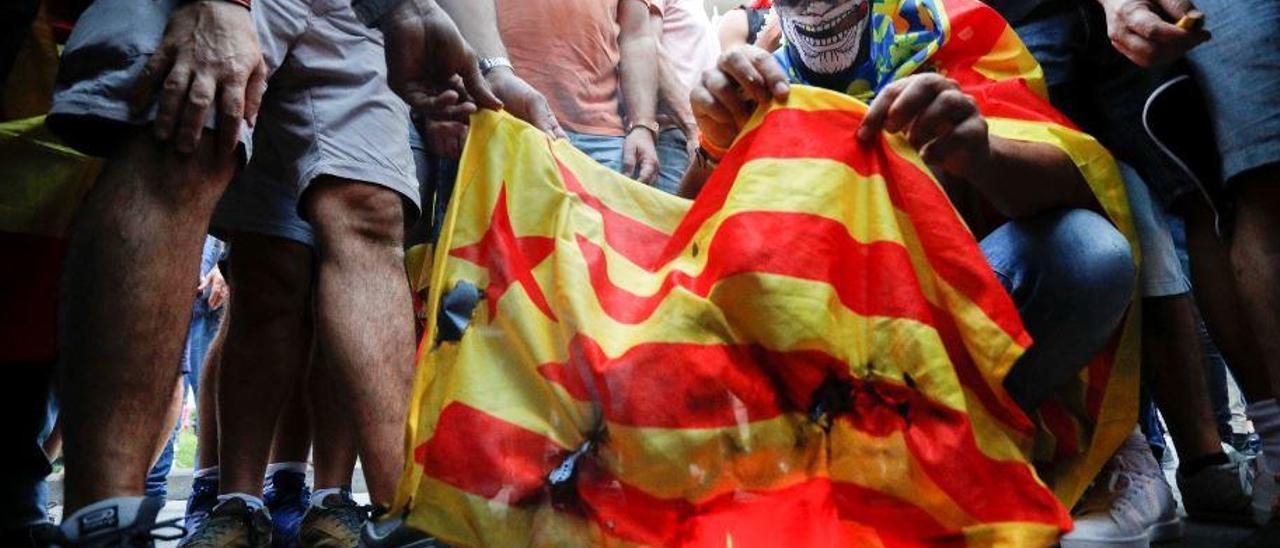 Manifestantes de extrema derecha queman una bandera independentista catalana en los altercados durante la manifestación del Nou de Octubre de 2017 en València.