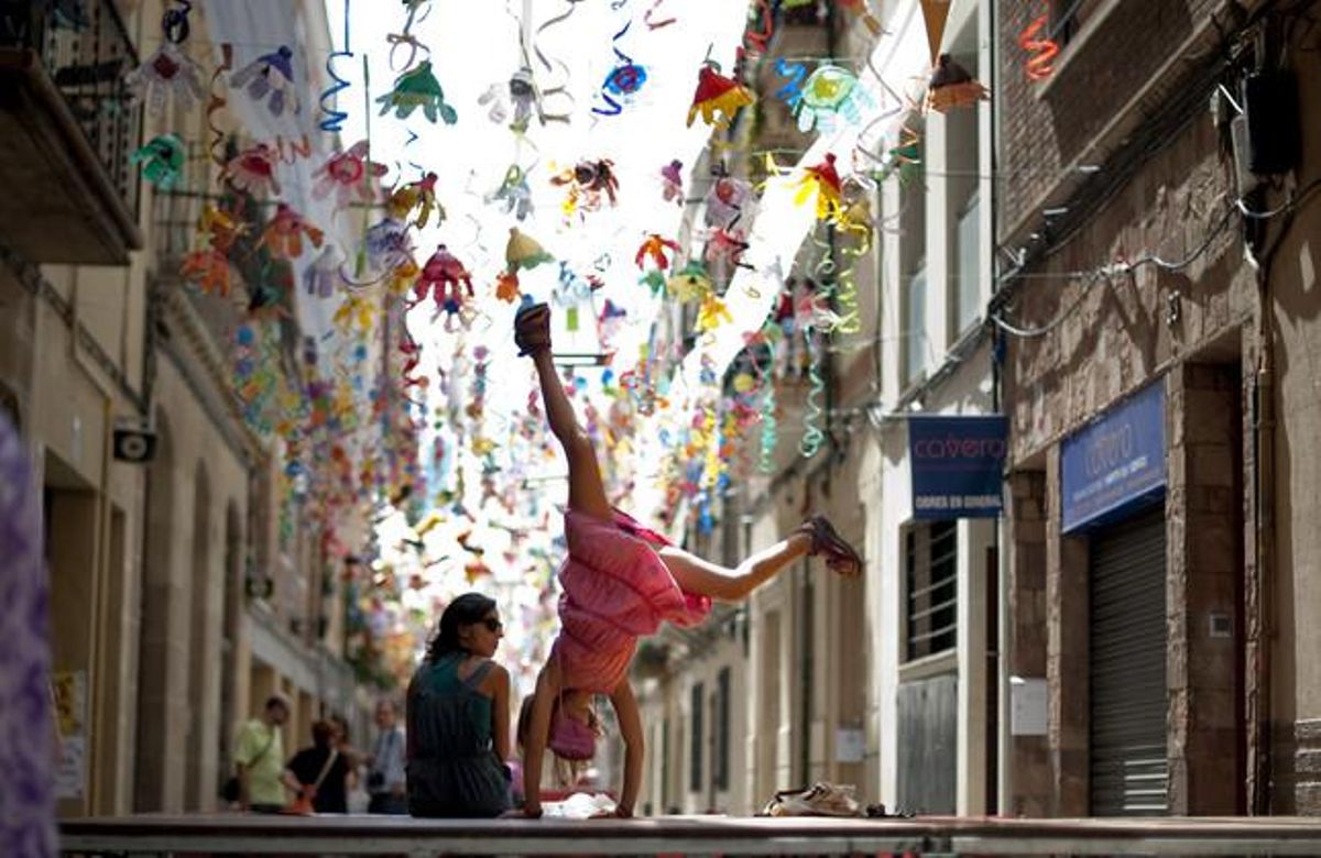 Una nena fa acrobàcies sota el decorat del carrer de Camprodon.
