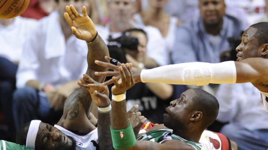 El jugador de Celtics Mickael Pietrus (c) disputa el balón con LeBron James (i) y Dwayne Wade (d), de Heat.