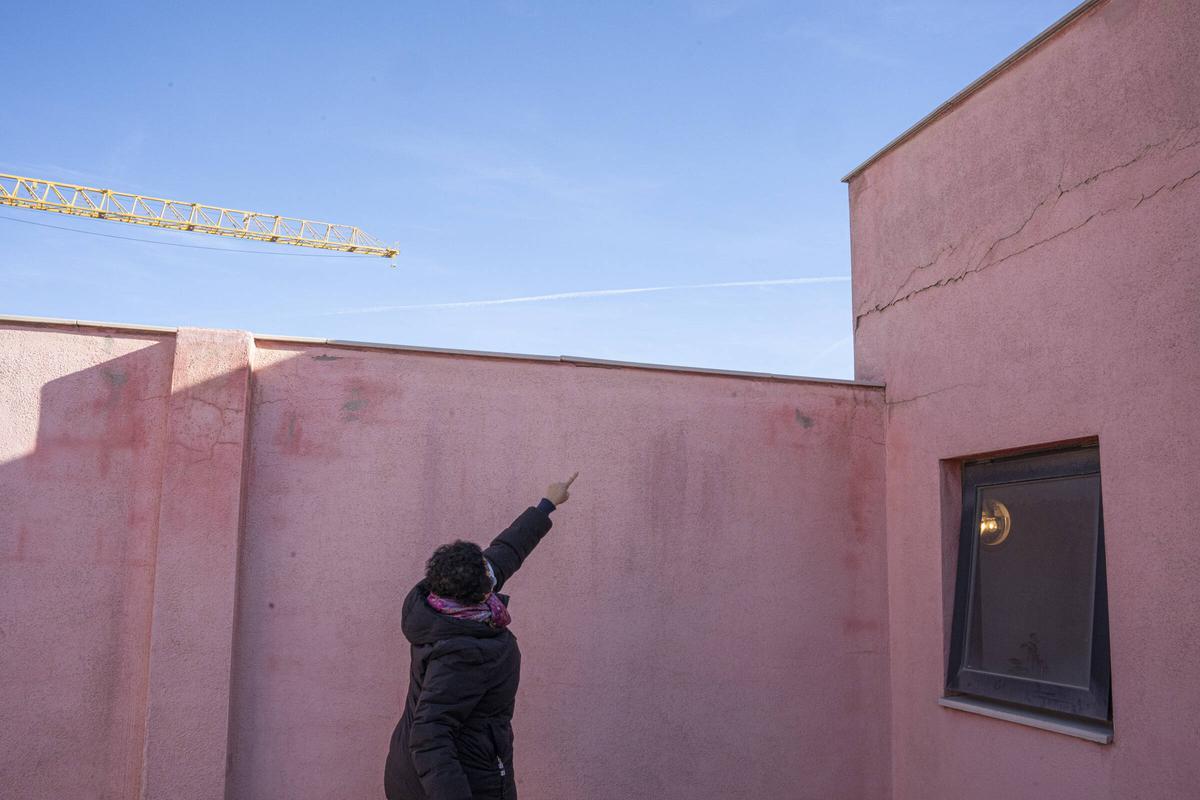 Una vecina señala unas grietas en la terraza de la comunidad que ha demandado a Limañ y al Barça por daños presuntamente causados por las obras del Camp Nou, en Barcelona.