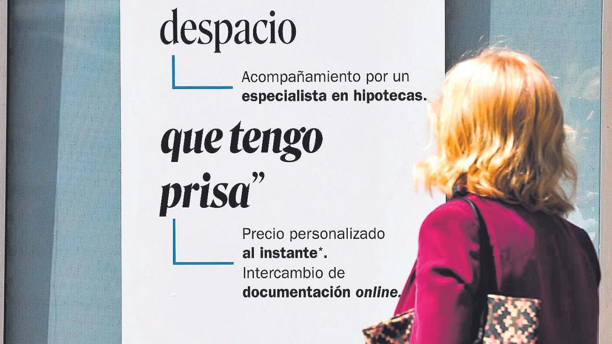 Una mujer mira un anuncio de hipotecas.