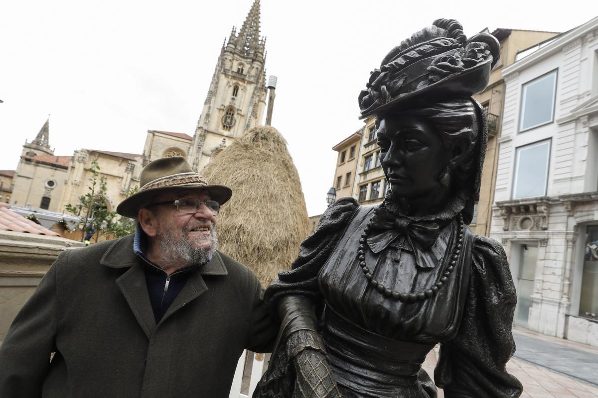 Mauro Álvarez sonriendo a la escultura de «La Regenta» con la Catedral de Oviedo detrás en 2022.