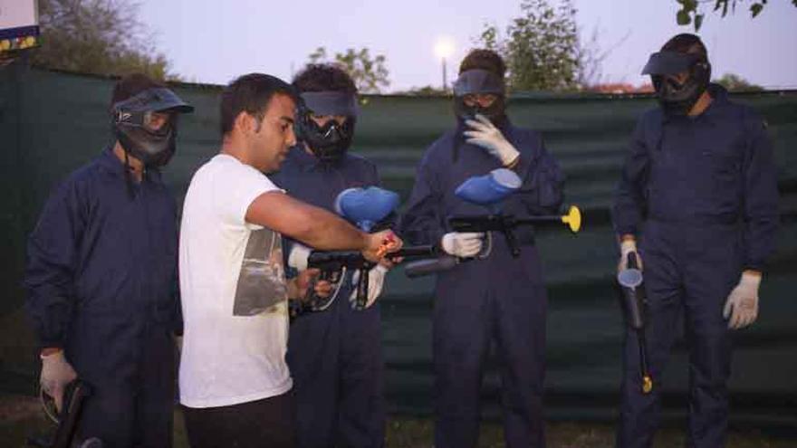 Un monitor enseña a un equipo a utilizar la armas de pintura.