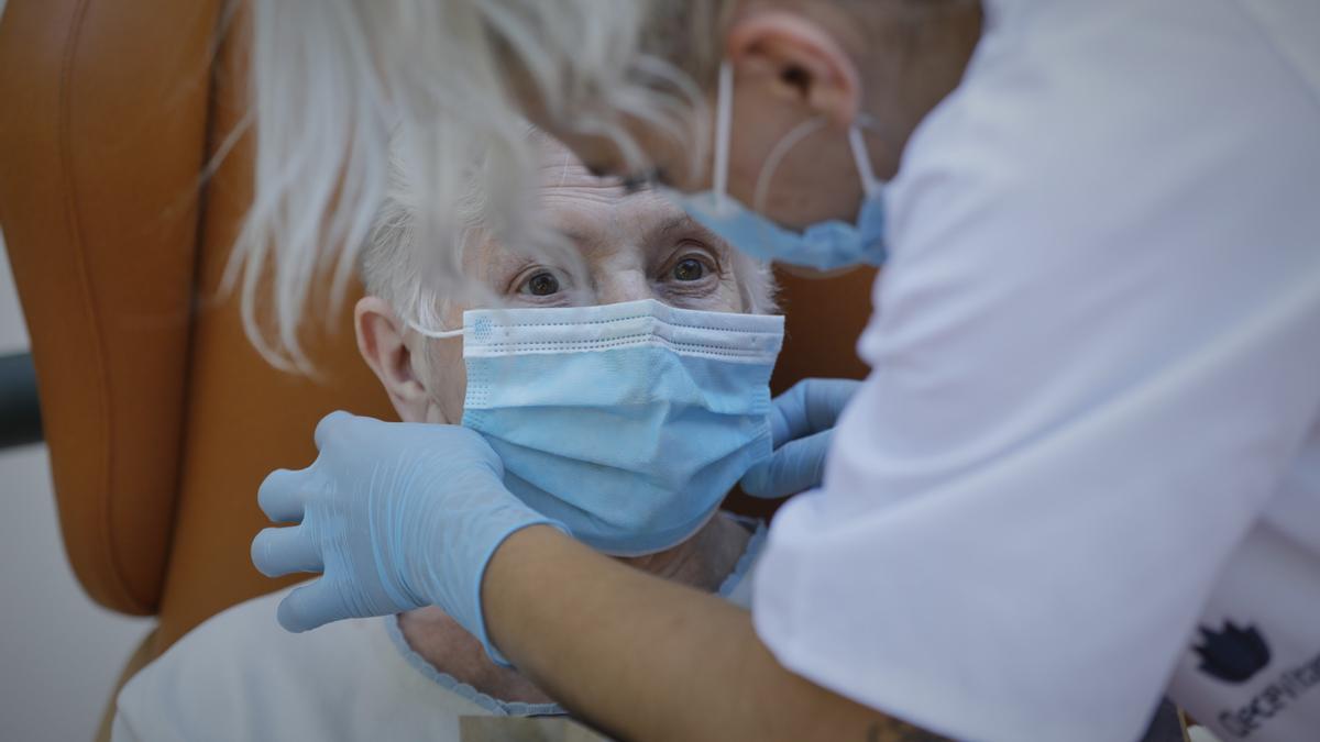 Una mujer con mascarilla en una residencia de mayores.