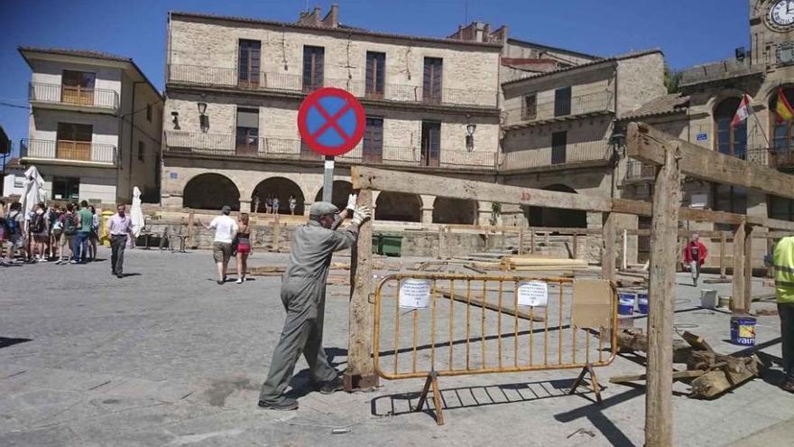 La colocación de las piezas de la plaza de madera se lleva adelante en presencia de un grupo de turistas que visitan Fermoselle.