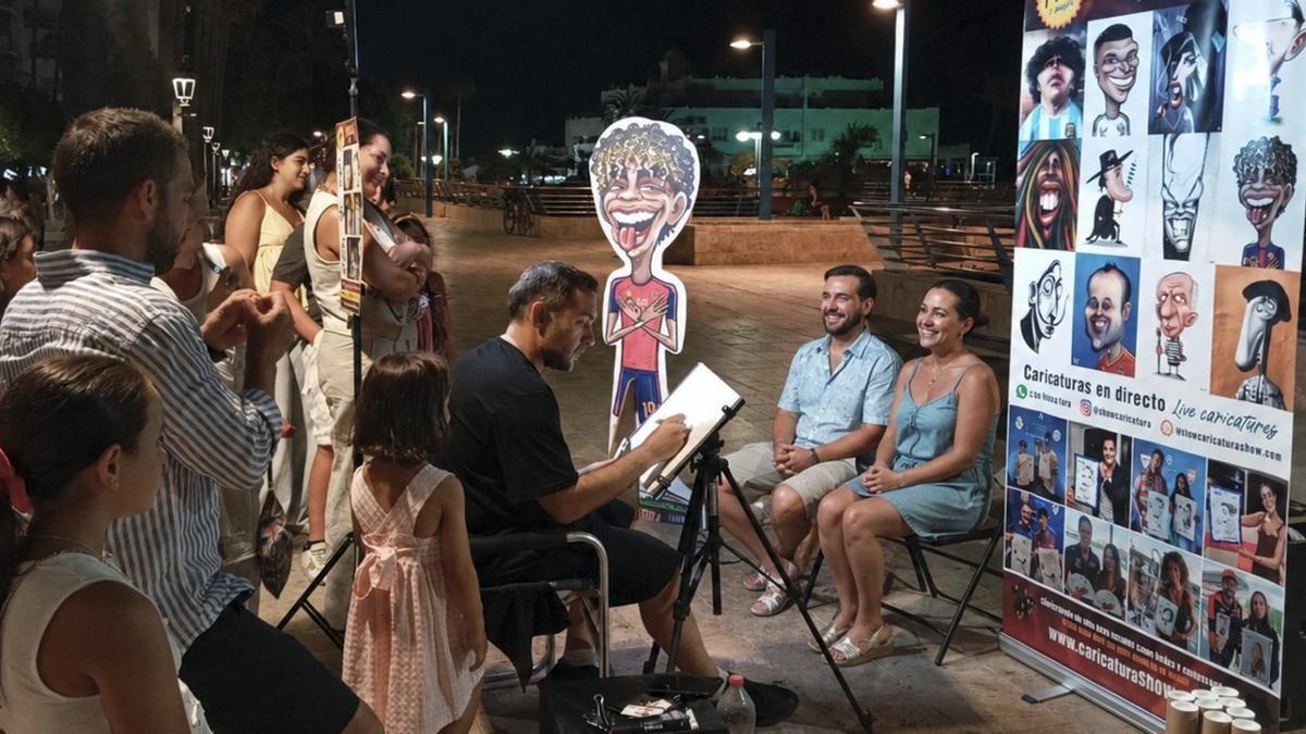 Un caricaturista retrata a dos turistas en el paseo marítimo de Marbella.