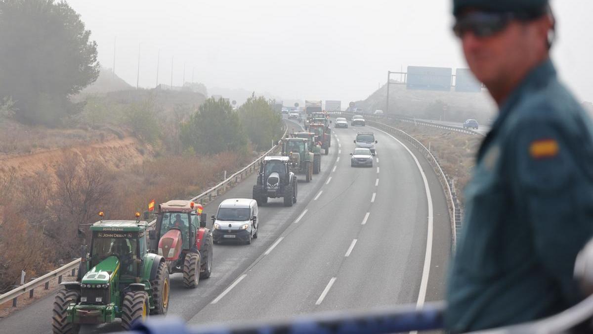 Los tractores pasan el Puerto de la Cadena ante la vigilancia de la Guardia Civil.