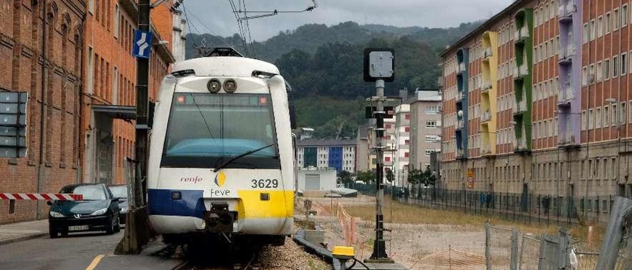 El tren circula en La Felguera al lado de la zona bajo la que se construyó el túnel.