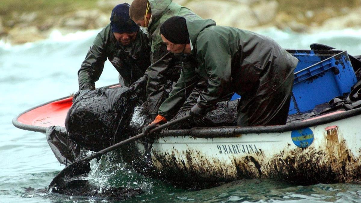 Pescadores recogen el fuel vertido en Aguiño.