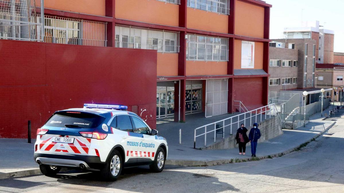 L'institut Enric Borràs de Badalona, amb una patrulla dels Mossos d'Esquadra a la porta.