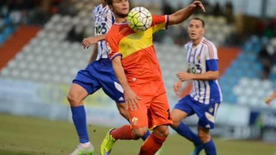 El jugador ilicitano Álvaro trata de controlar un pelota ante la presencia de Miquel y de Alan Baró.