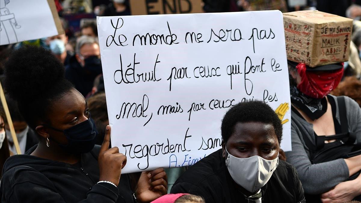 zentauroepp53706000 a woman wearing face mask holds a placard reading   the worl200609204030