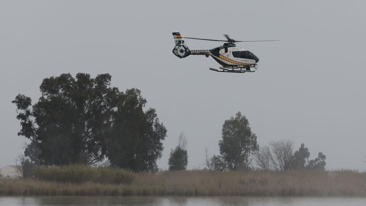 Un helicóptero de la Guardia Civil vigila el río Guadalquivir en la localidad sevillana de Lebrija durante la búsqueda reactivada en la zona de choque de dos narcolanchas.