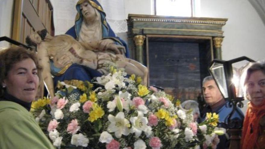 Varios cofrades de Santa Cristina preparan la imagen de la Virgen de los Dolores.