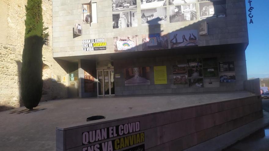 La façana de la biblioteca de Castelló d'Empúries exposa imatges de la pandèmia