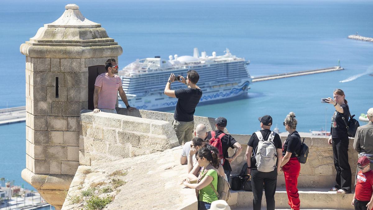 Turistas se fotografían en el castillo de Santa Bárbara, en una imagen reciente, con un crucero al fondo.