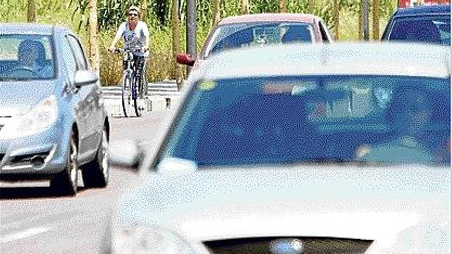 Una ciclista circula entre la jungla de coches de la ronda norte.