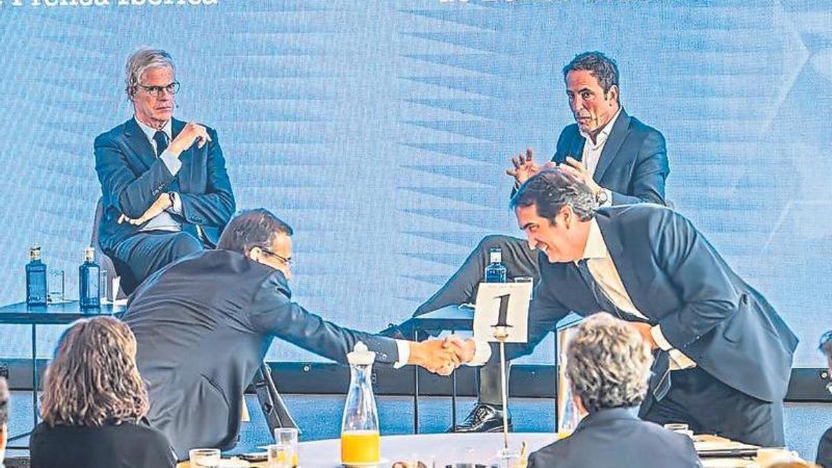 Carlos Ventura, del Banco Sabadell, (al fondo a la dcha.) mira mientras saludan a Peio Belausteguigoitia, del BBVA (dcha.).